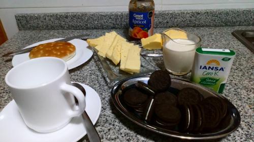 a table with a cup of coffee and a plate of food at Hostal Parcela 47 villarrica in Villarrica