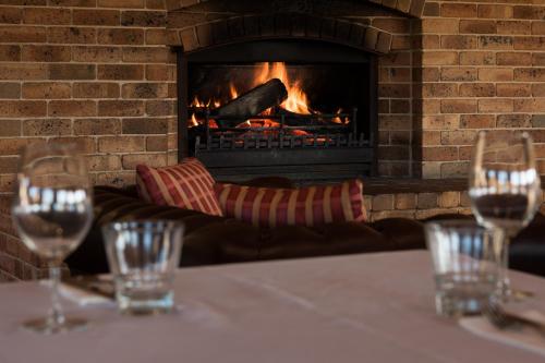 
a fireplace that has a fire place in it at Bowen Inn Motel in Lithgow
