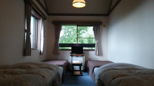 Habitación con 2 camas y ventana en Do Sports Plaza Madarao, en Iiyama