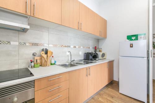 a kitchen with a sink and a refrigerator at Faro Cosy Guesthouse in Faro