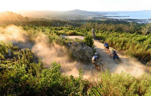 two people riding mountain bikes down a dirt road at Millennium Hotel Rotorua in Rotorua