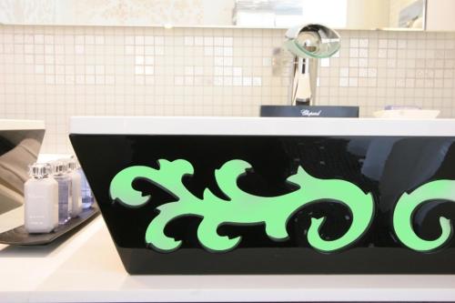 a sink with a green sign on the side of it at Hôtel Princesse Flore in Royat