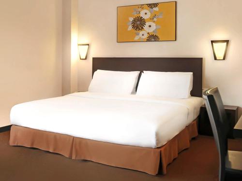 a bedroom with a large white bed in a room at Hotel Summer View in Kuala Lumpur