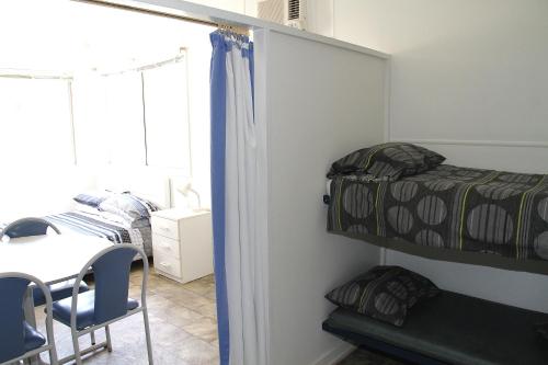 a bedroom with bunk beds and a table and chairs at Port Lincoln Caravan Park in North Shields