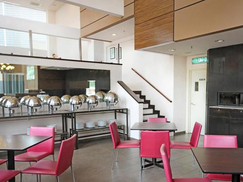 a restaurant with tables and chairs and a staircase at Hotel Summer View in Kuala Lumpur