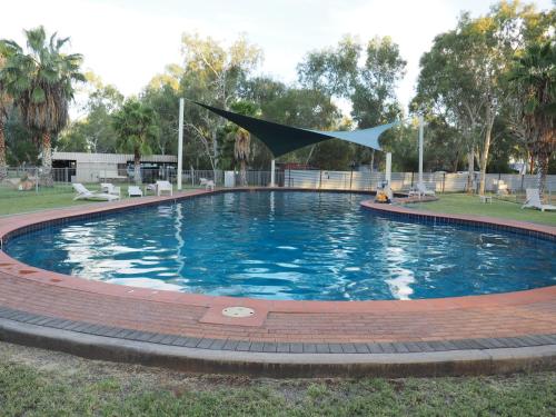een groot zwembad met een vlag in het midden bij Heritage Caravan Park in Alice Springs