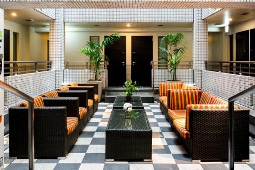 東京にある上野ホテルのソファ、テーブル、植物のあるロビー