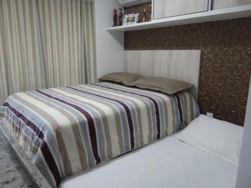 a bedroom with a bed with a striped blanket at Mar Bello Plaza in Cabedelo