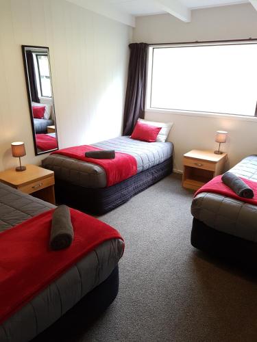 a hotel room with two beds and a mirror at Mt Aspiring Holiday Park in Wanaka