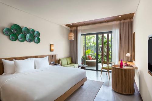 a bedroom with a bed and a living room at Dusit Princess Moonrise Beach Resort in Phu Quoc