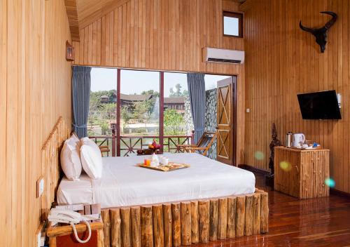 a bedroom with a bed and a large window at KMA SHWE PYI BAGO Resort in Bago