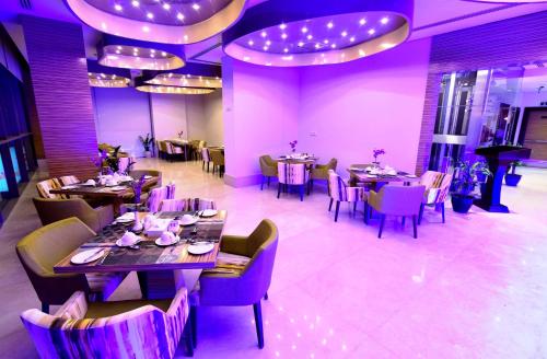 a dining room with tables and chairs and purple lighting at Best Western Plus Pearl Creek in Dubai