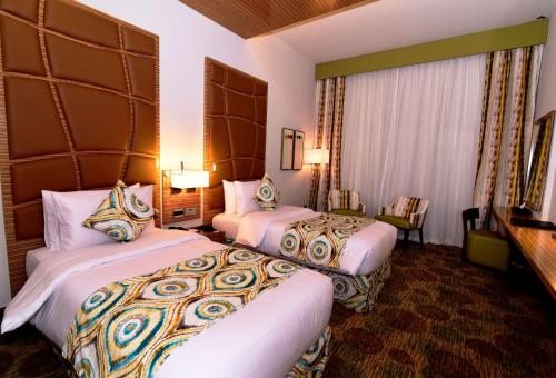 a hotel room with two beds in a room at Best Western Plus Pearl Creek in Dubai