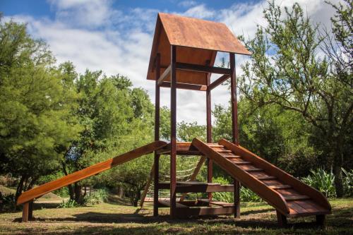 a wooden playground with a lookout tower and stairs at Cabañas Mirasoles in Villa General Belgrano