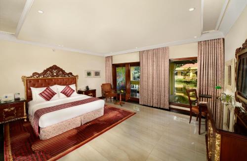 a bedroom with a bed and a large window at Mayfair Lagoon in Bhubaneshwar