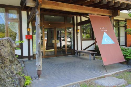 a building with a sign in front of it at Guesthouse E-ne in Oshino