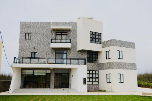 a large white building with black windows at Destination Inn in Magong