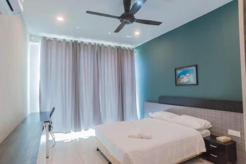 a bedroom with a bed with a ceiling fan at C Residence Labuan in Labuan