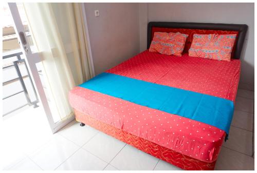 a bed in a room with a red and blue at Budi House & Food Station in Bandung