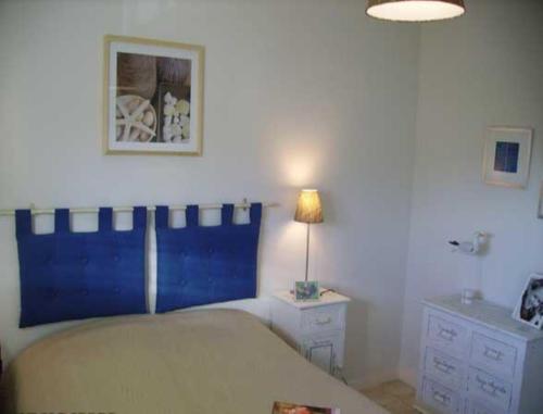 a bedroom with a bed and a lamp on a table at Le Sémaphore in Cayeux-sur-Mer