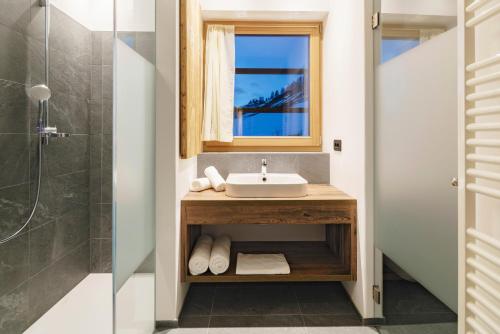 baño con lavabo y ventana en Plang Farmhouse en San Cassiano