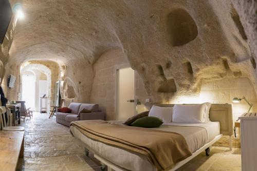 a bedroom with a large bed in a stone wall at Thymus Residence nei Sassi in Matera