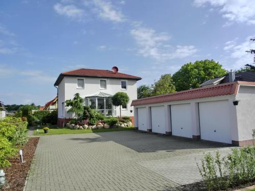 a large white house with two garages at Fewo Graal in Graal-Müritz