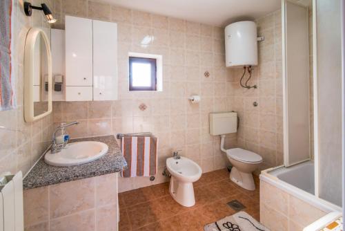 a bathroom with a sink and a toilet and a tub at Apartment Sandra Krk in Krk