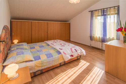 a bedroom with a large bed and a wooden cabinet at Apartment Sandra Krk in Krk
