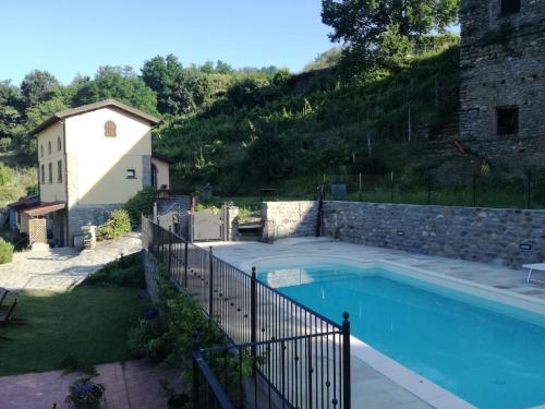a swimming pool in a yard with a stone wall at agriturismo il poderetto in Licciana Nardi