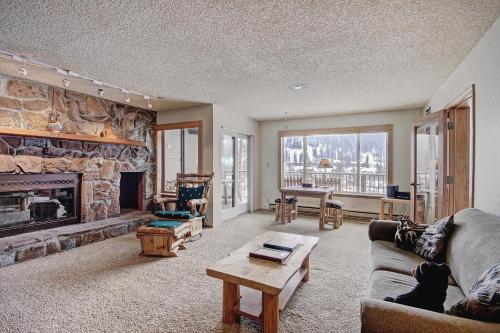 sala de estar con chimenea de piedra y sofá en Cri221 Cinnamon Ridge Condo en Keystone