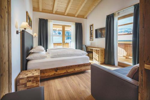 a bedroom with a bed and a chair and a window at Plang Farmhouse in San Cassiano