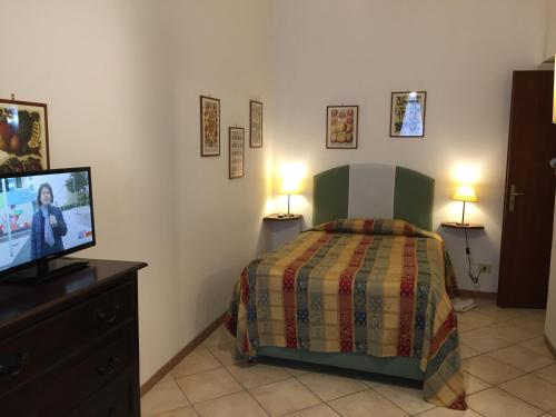 een slaapkamer met een bed en een flatscreen-tv bij La Residenza dei Nobili in Catanzaro