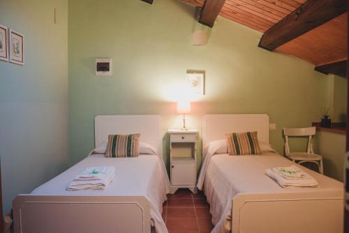 a bedroom with two beds and a table with a lamp at Casale Torre San Magno in Corato