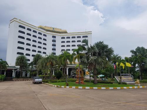 a large white building with palm trees in front of it at Royal Mekong Riverside Hotel in Nong Khai