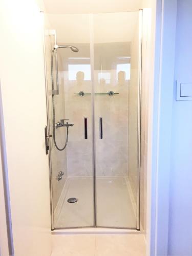 a shower with a glass door in a bathroom at Apartments Mija in Bol