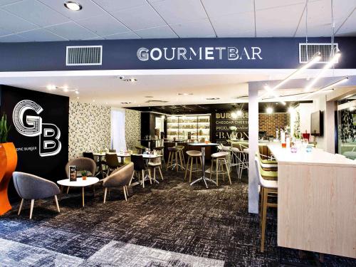 a restaurant with tables and chairs and a bar at Novotel Toulouse Purpan Aéroport in Toulouse