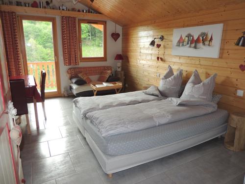 een slaapkamer met een bed in een houten kamer bij Au Bout du Chemin in Hohrod