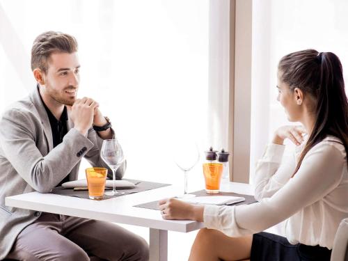 a man and a woman sitting at a table at Novotel Athens in Athens