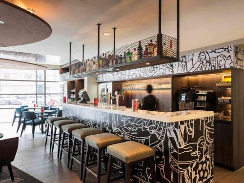 a restaurant with a bar with stools at ibis Amsterdam Centre Stopera in Amsterdam