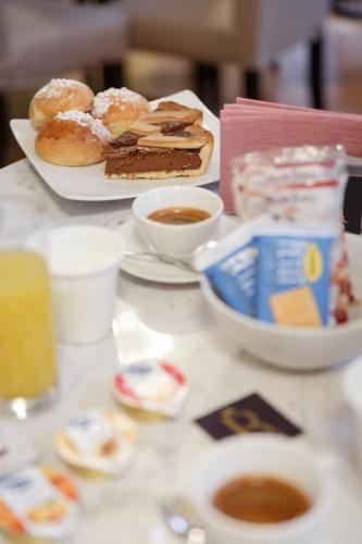 a table with a plate of donuts and a bowl of coffee at Il Salotto della Regina in Naples