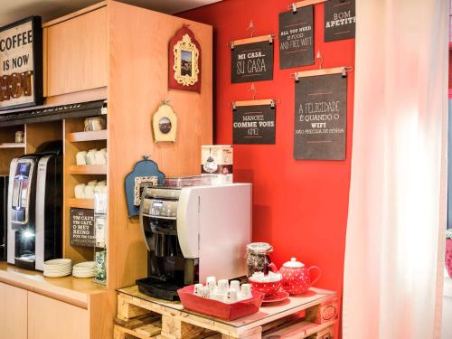 a coffee shop with a espresso machine on a counter at ibis Porto Centro São Bento in Porto