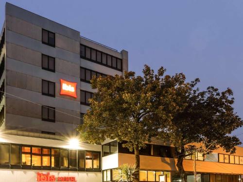 a building with a red sign in front of it at ibis Porto Centro São Bento in Porto