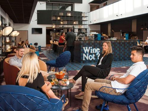 a group of people sitting in chairs in a restaurant at Hotel Mercure Blois Centre in Blois