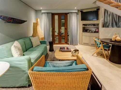 a living room with a green couch and a table at Sofitel Legend Santa Clara Cartagena in Cartagena de Indias