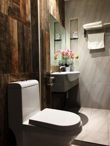 a bathroom with a white toilet and a sink at Meriton Inn in Kuantan