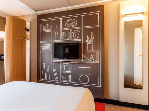 a bedroom with a chalkboard wall with a tv at ibis Amsterdam City West in Amsterdam
