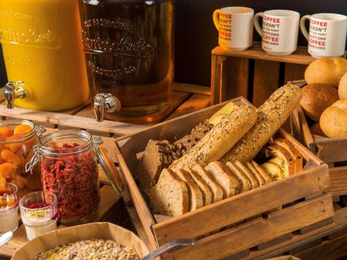 a bunch of different types of bread and other foods at ibis Amsterdam City West in Amsterdam