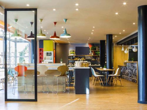 a room with chairs and tables and a kitchen at Ibis Granada in Granada