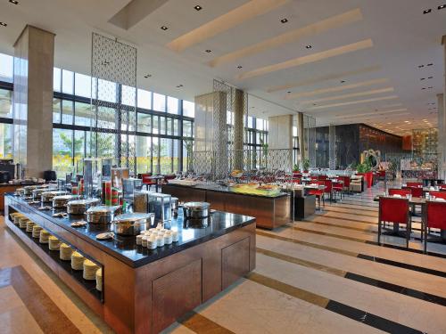 a restaurant with tables and chairs in a building at Novotel Kolkata Hotel and Residences in Kolkata